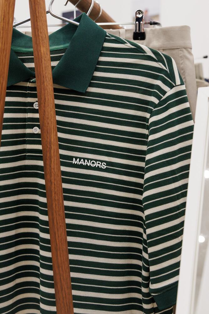 A green and cream striped polo on a hanger.