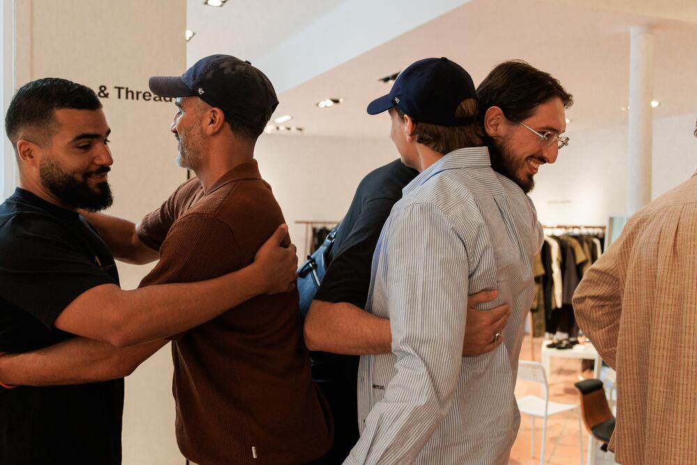 Friends greeting each other with a hug in the showroom.