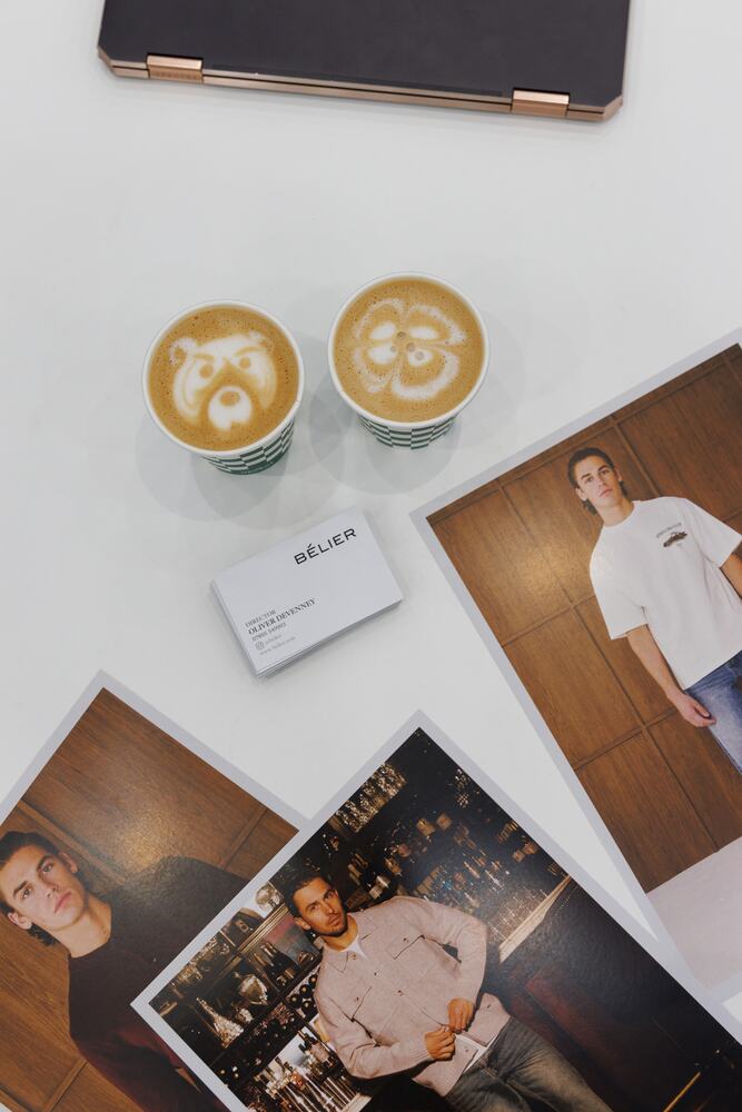 Two coffees with latte art beside lookbook prints.
