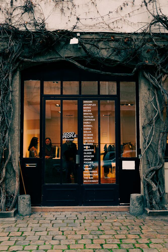 The showroom doorway under the ivy, lit from inside.