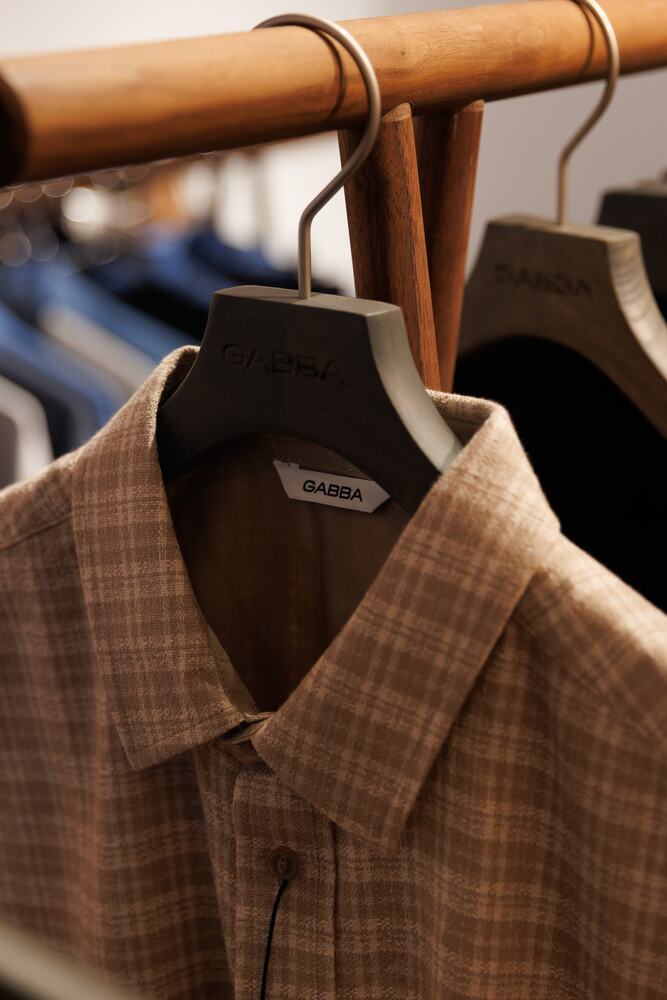 A checked shirt on a wooden hanger.