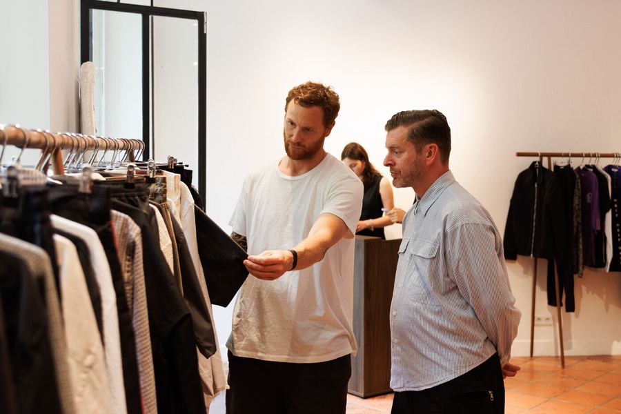 A brand showing a jacket to a buyer at the rail.