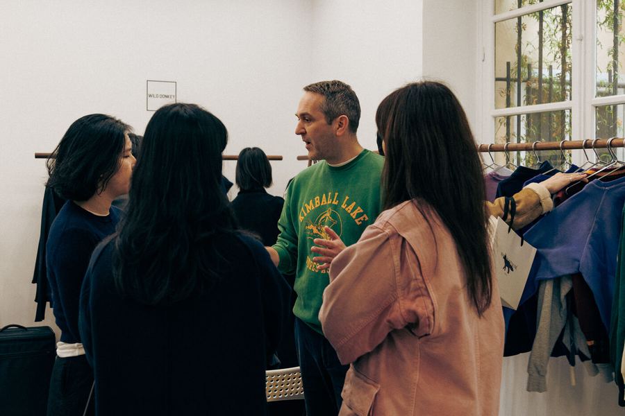 Buyers and brands in conversation by the rails.