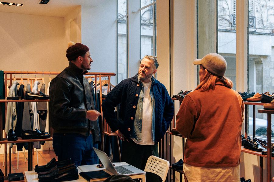 Three people talking at a busy rail.