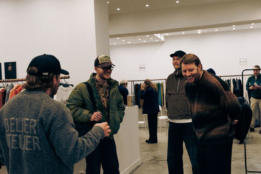 Visitors in caps and jackets talking in the showroom.
