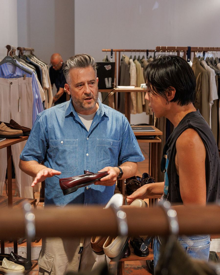A brand holding up a piece at the rail for a buyer.